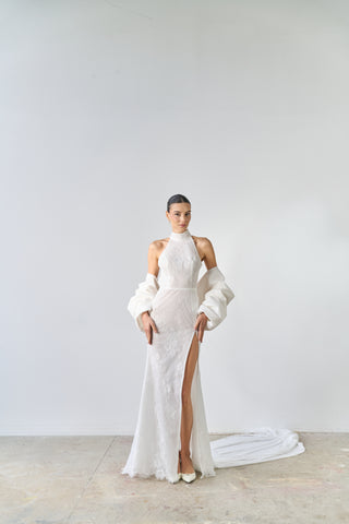 Model wearing a white high-neck gown with cut-out sides against a plain background