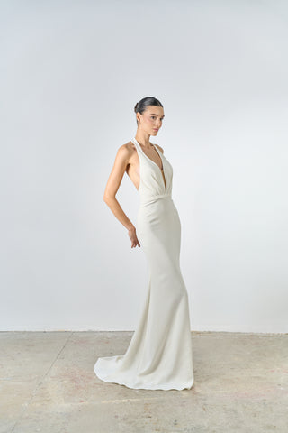 Woman wearing a white evening gown against a plain background