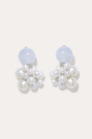 Sculptural earrings with contemporary design, featuring organic, flowing curves and clusters of elegant freshwater pearls.