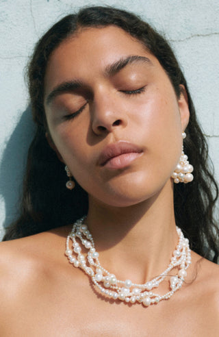 Sculptural necklace featuring cascading freshwater pearls along a fluid, handcrafted chain, designed to rest elegantly above the collarbone.