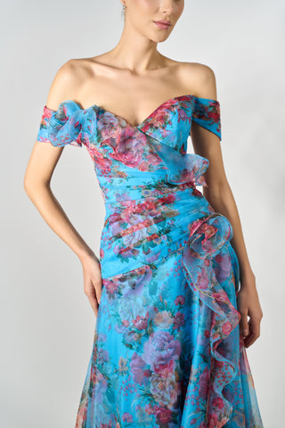 Woman wearing a floral off-shoulder dress against a plain background