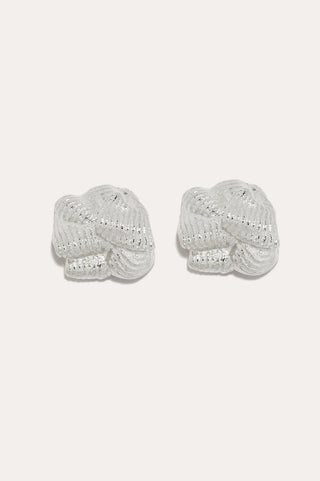 Statement silver-plated earrings with a sculpted, knotted design perfect for high-fashion occasions.