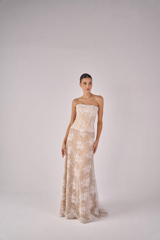 Woman wearing a strapless floral gown on a white background