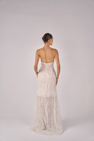 Woman wearing a strapless lace dress on a white background