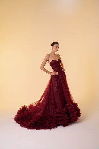 Timeless strapless ball gown with dazzling sparkle finish, sweetheart neckline, and a dramatic ruffled hemline for special occasions