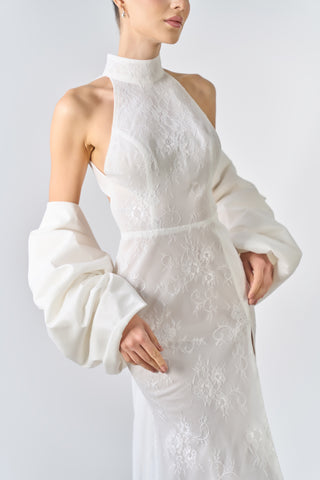 White lace dress with long sleeves on a plain background