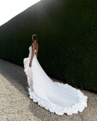 Strapless bridal gown featuring a contemporary high-low silhouette and intricate couture-inspired ruffle detailing.