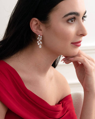 Woman wearing a red dress and earrings with a neutral background