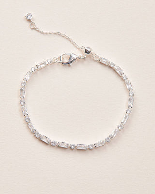 Silver bracelet with clear stones on a beige background