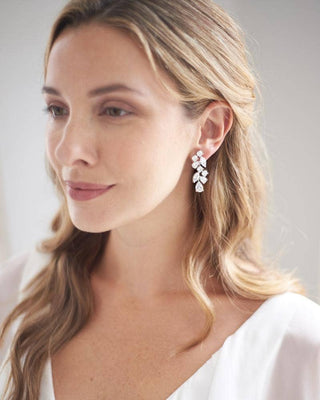 Woman wearing floral earrings with a neutral background