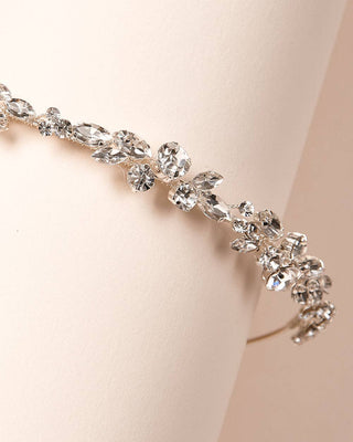 Silver tiara with clear crystals on a beige background
