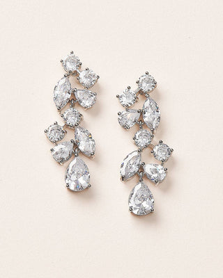 Pair of sparkling diamond earrings on a light pink background