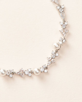 Necklace with pearls and crystals on a light beige background