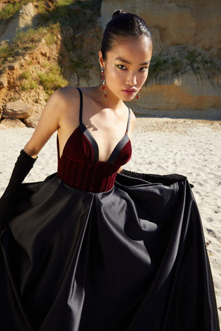 Sophisticated evening dress with a fitted corset top, plunging neckline, and voluminous skirt ideal for black-tie occasions.