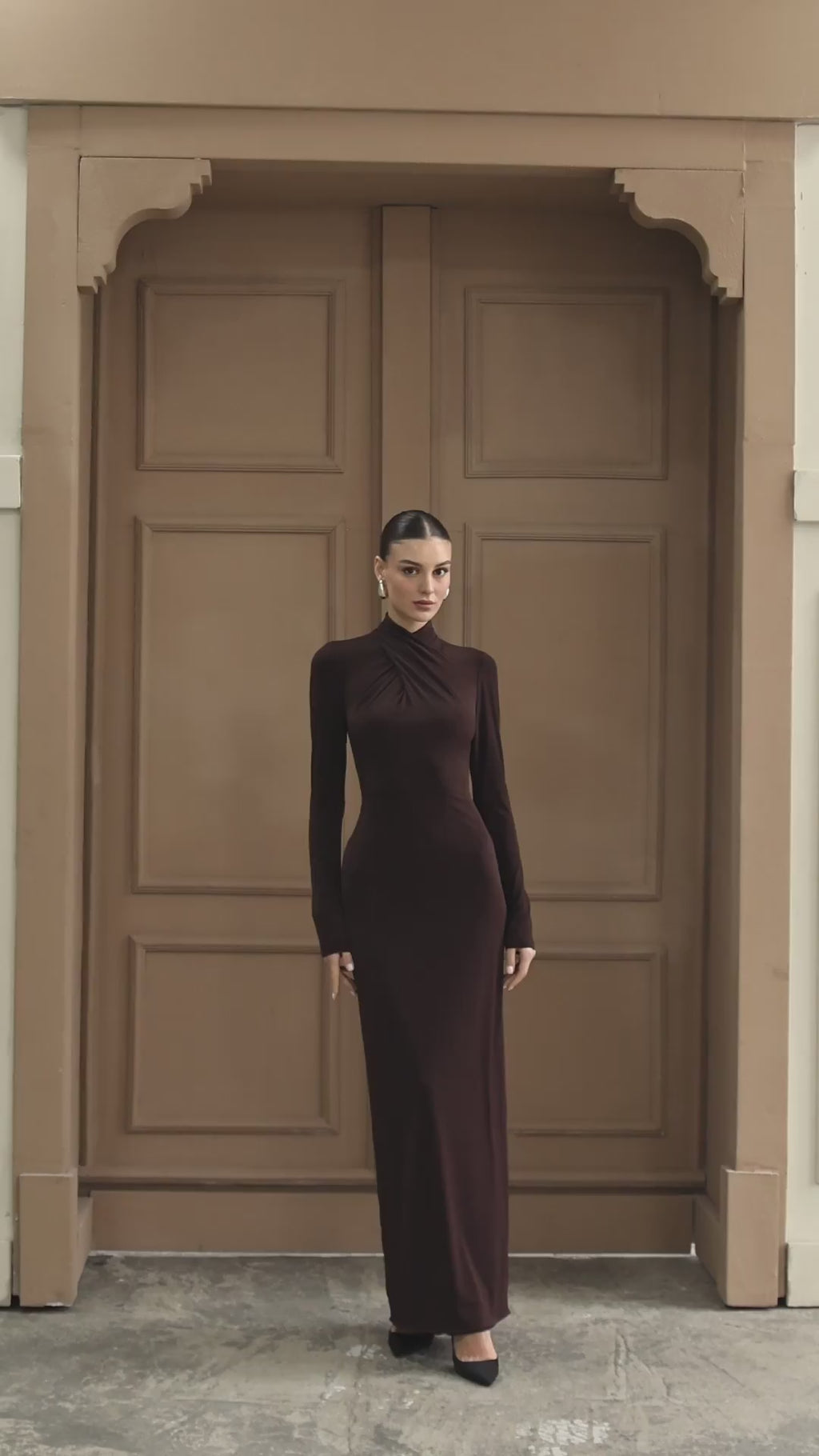 Modern evening gown with a high turtleneck design, long sleeves, and a seamless sheath silhouette.