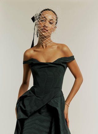 Three-quarter close-up of the Tabitha gown in black, highlighting the intricate draping and fabric details.